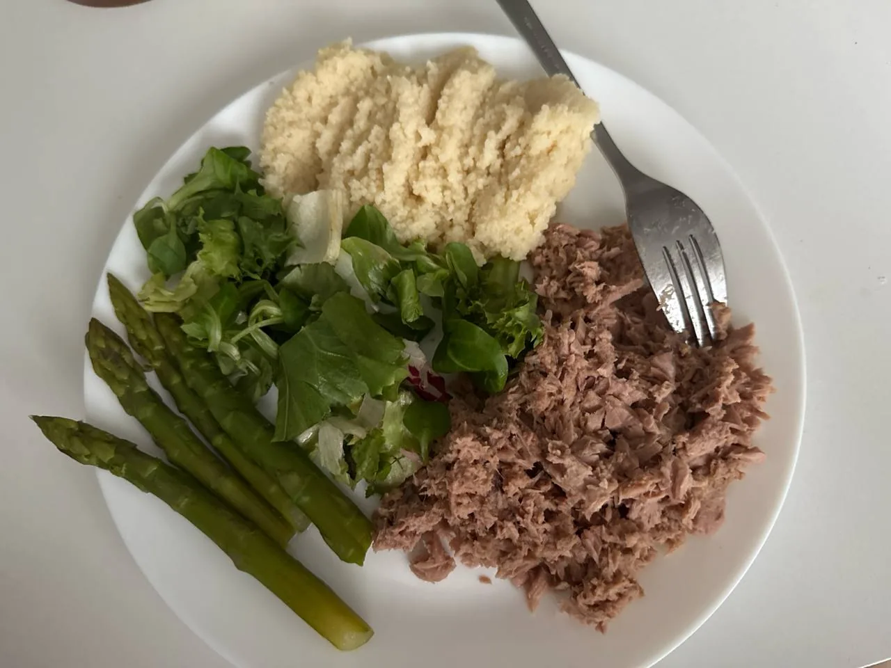 Тарелка с тунцом, кускусом, спаржей и зеленью как пример сбалансированного приема пищи при работе с психодиетологом онлайн